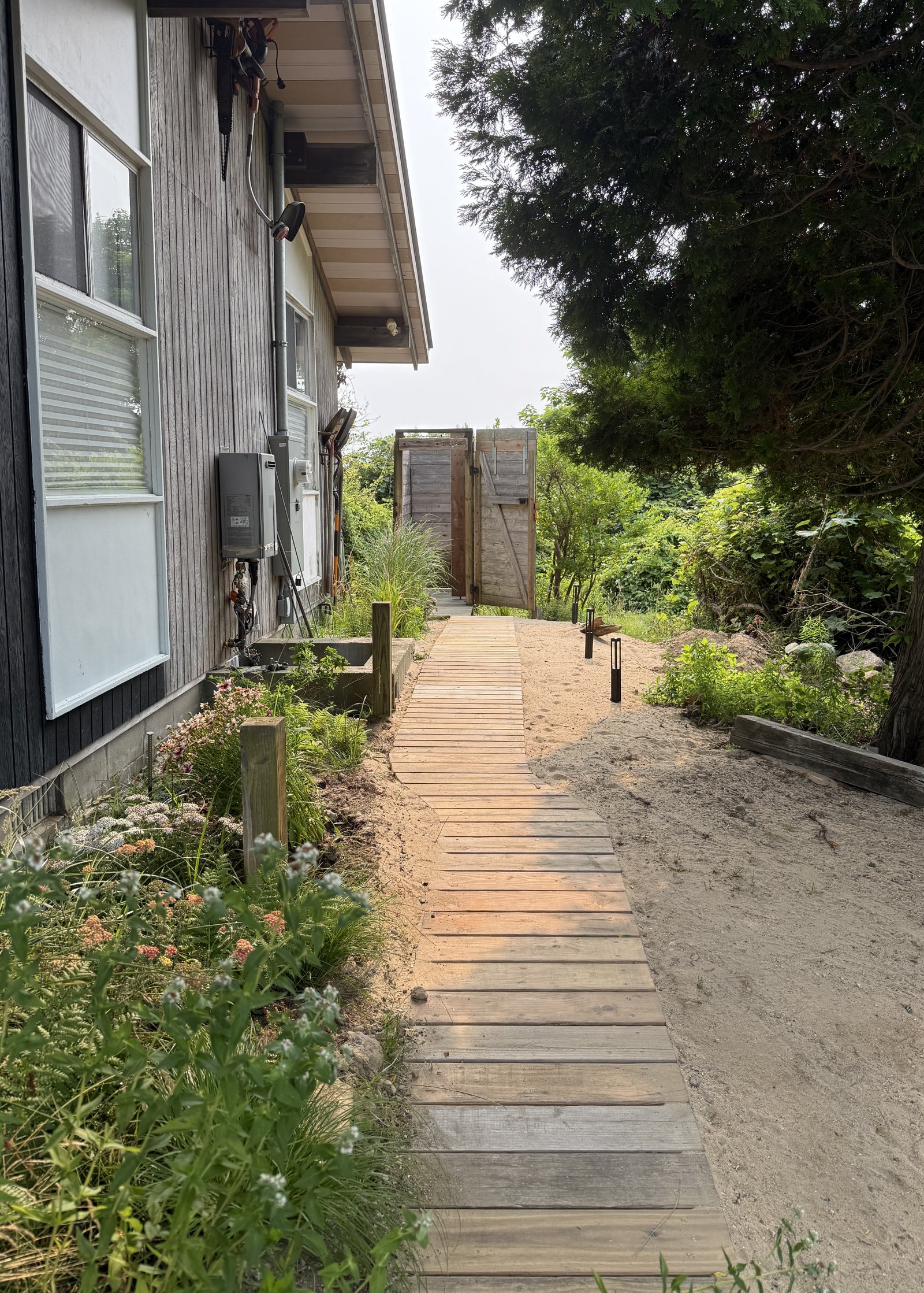 boardwalk through sand to outdoor shower enclosure