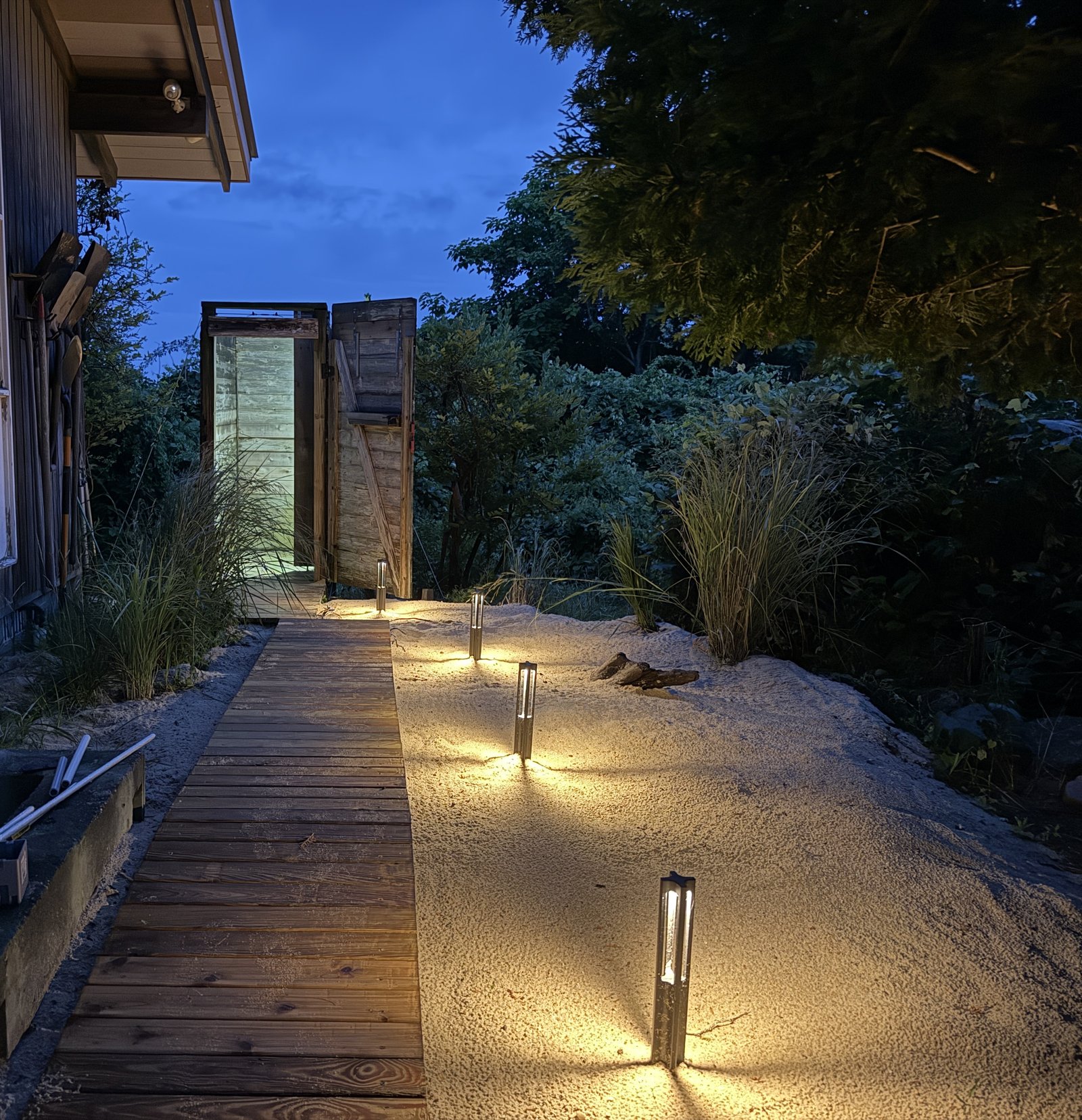 outdoor shower boardwalk in the evening with path lights and lighting inside the shower
