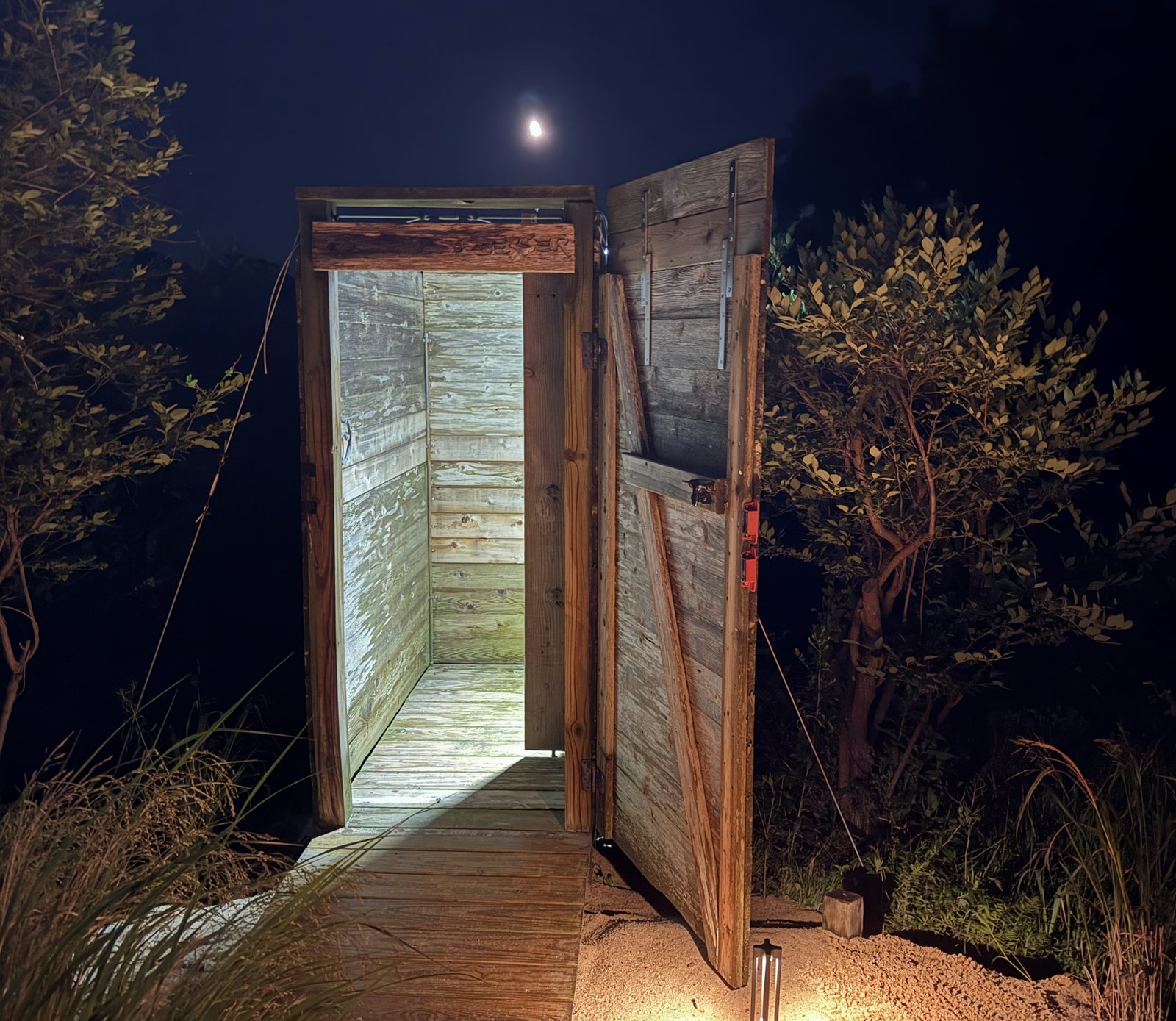 outdoor shower enclosure at night under the moon, with interior illumination