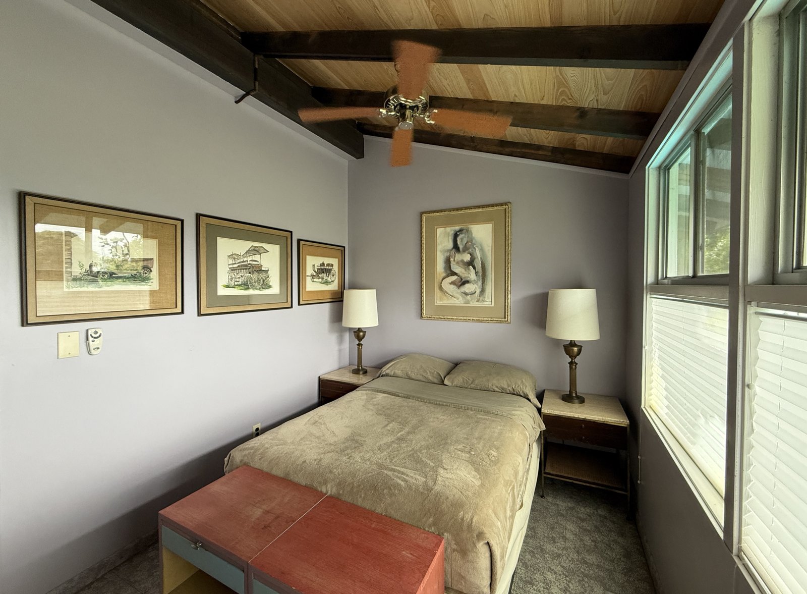 rear bedroom showing bed, nightstands, lamps, artwork on wall, ceiling fan, slowed cypress ceiling, natural light