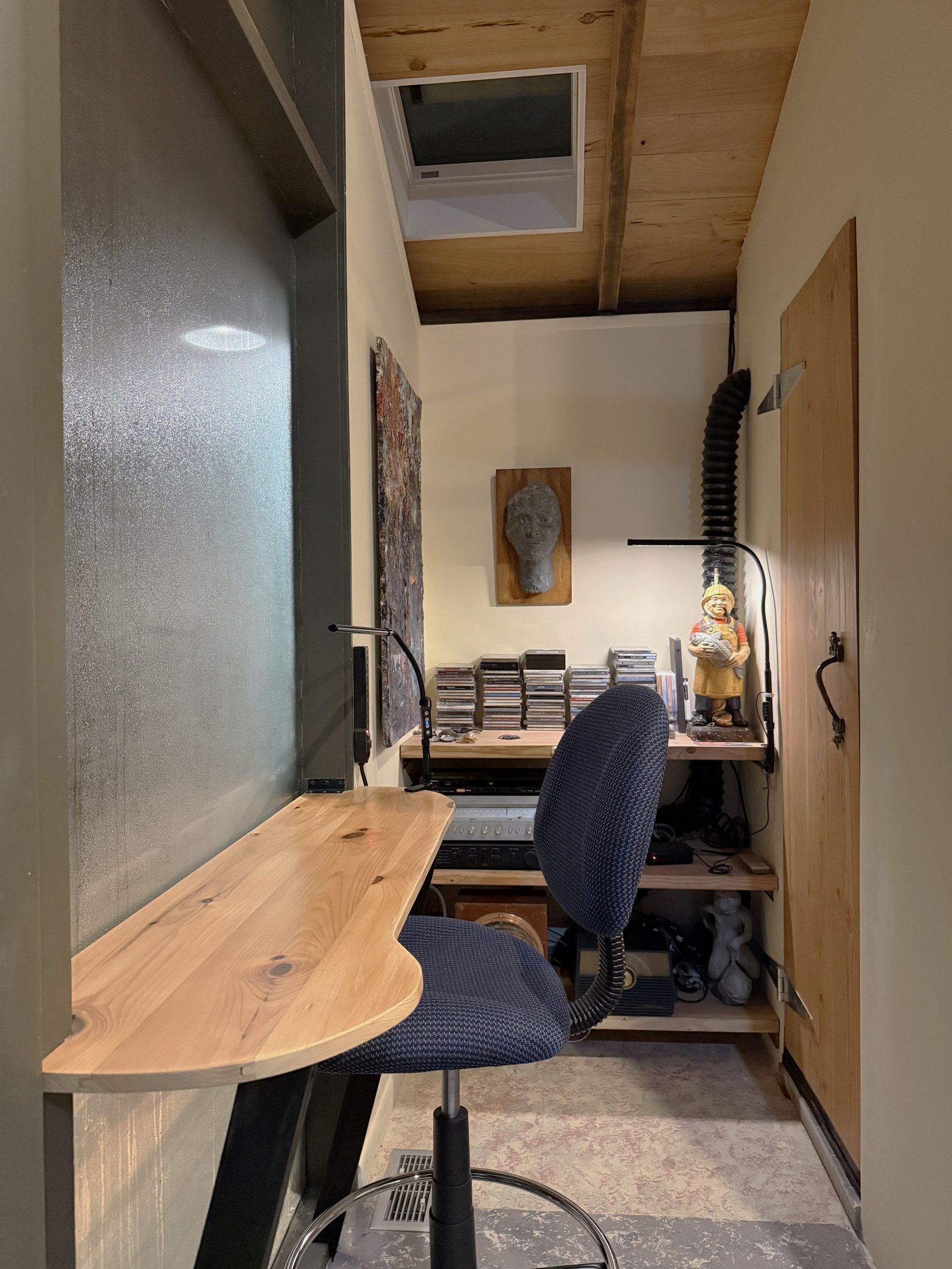 window counter workspace with a music nook behind.  the workspace can hold a laptop and papers and book, and the music nook includes an amplifier, CD player, and a cable to connect a cell phone for amplifying one's playlist over the house speakers.